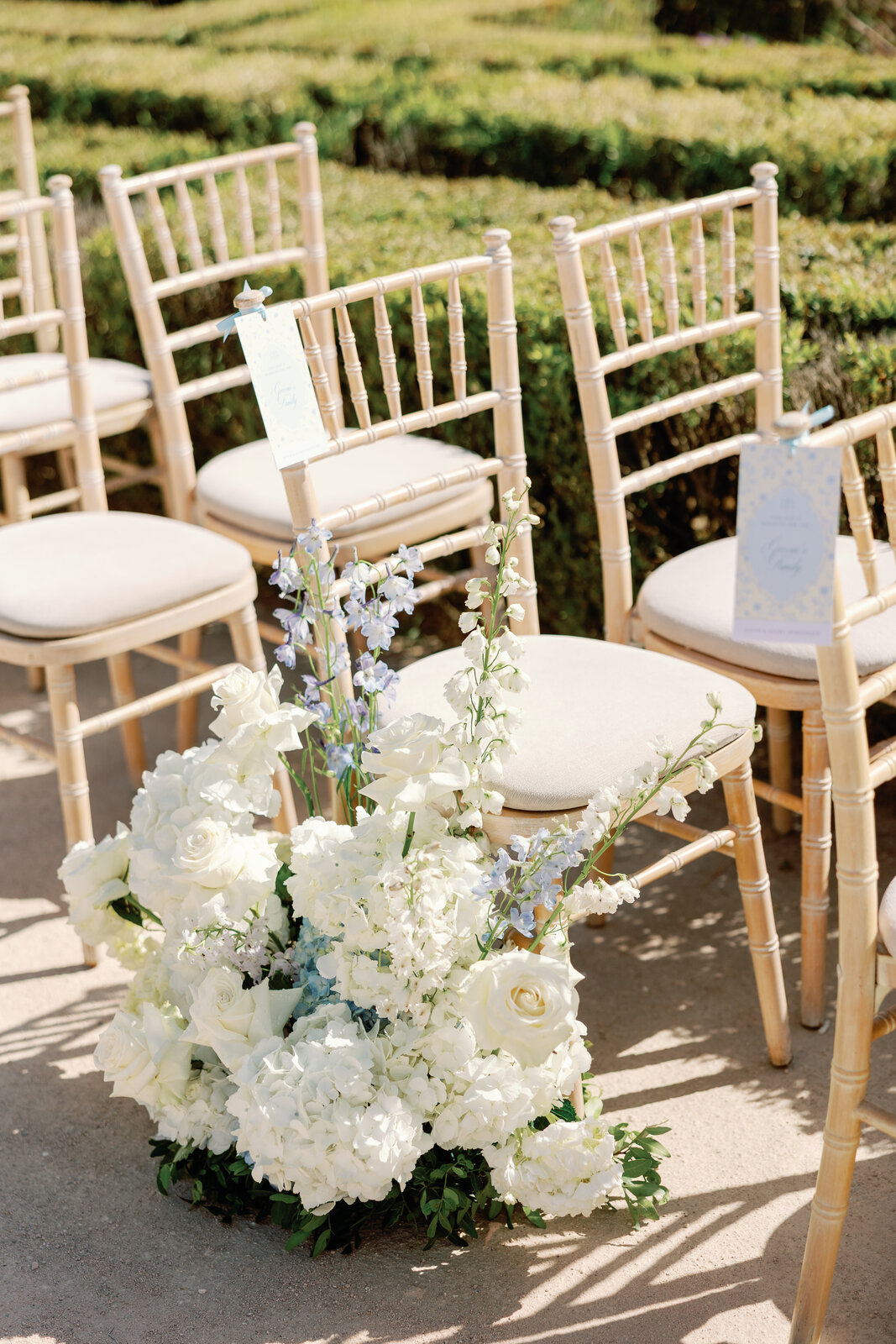 Close-up of ceremony chairs with floral arrangements