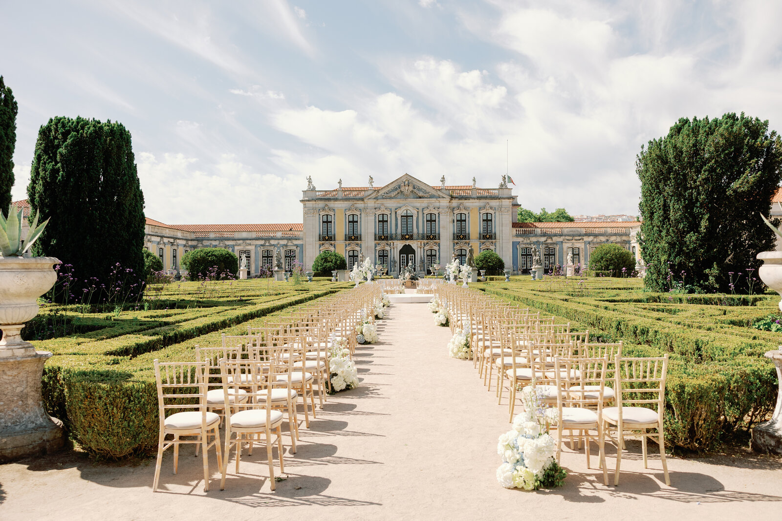 Ceremony aisle lined with chairs facing the palace