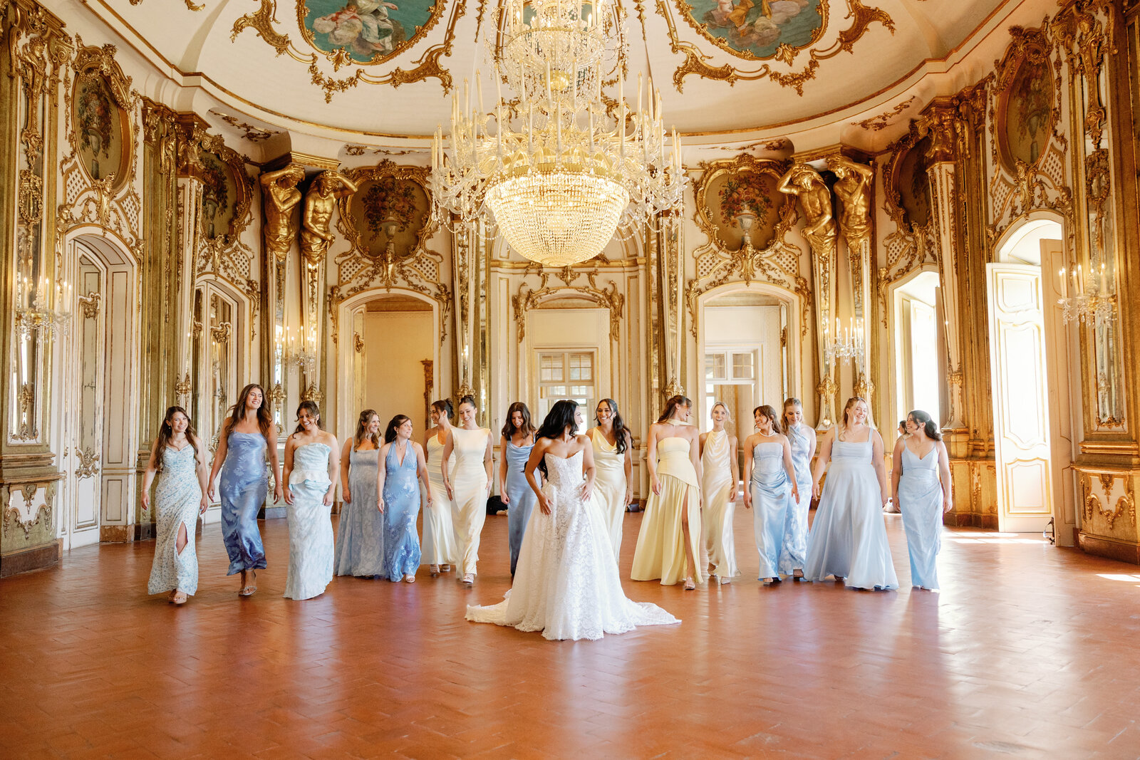 Bride and bridesmaids walking through the gilded ballroom