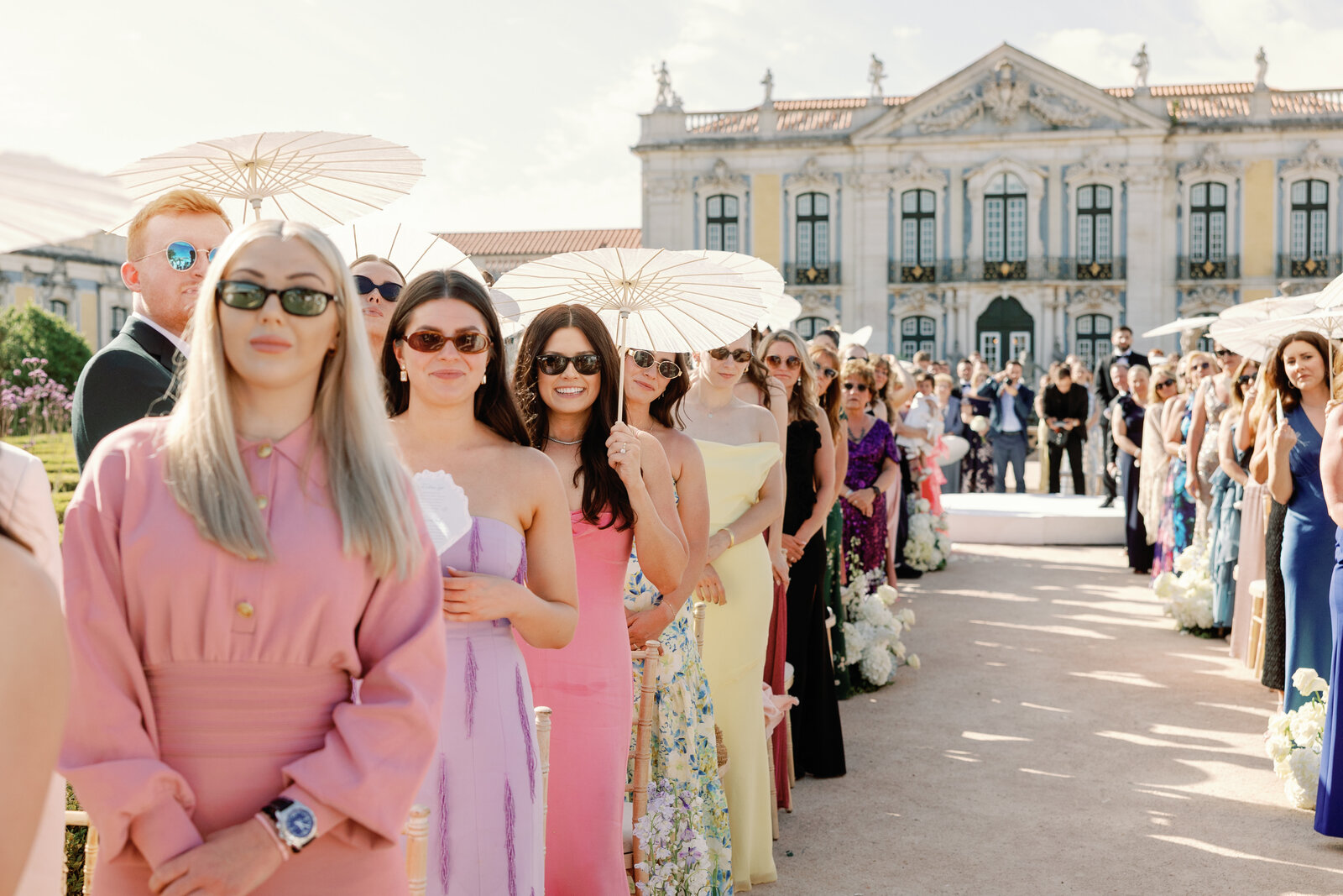Bridesmaids in colorful dresses standing with parasols