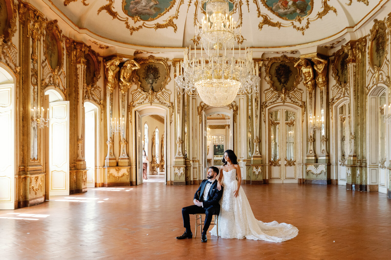Bride and groom beneath the crystal chandelier in the ballroom