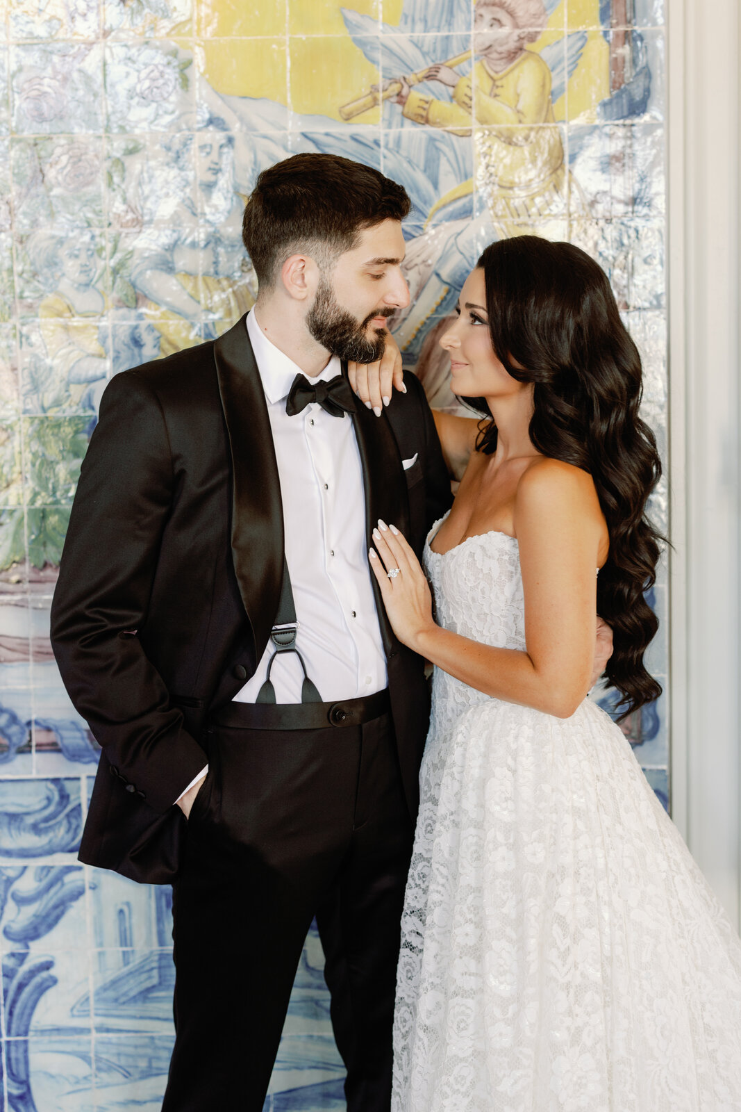 Bride and groom portrait against a blue and yellow azulejo tile mural