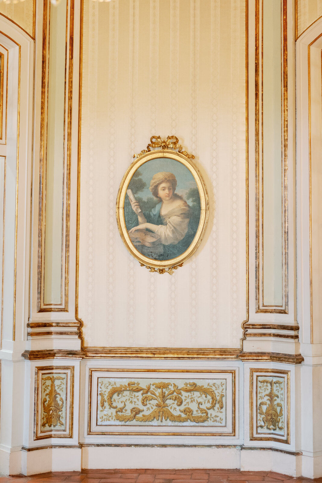 Detail of a gilded oval portrait painting in the palace hallway