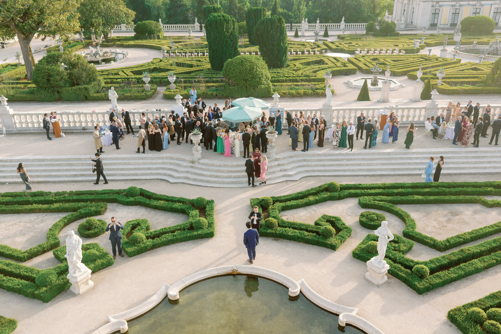 Top-down aerial view of guests gathered around the terrace bar
