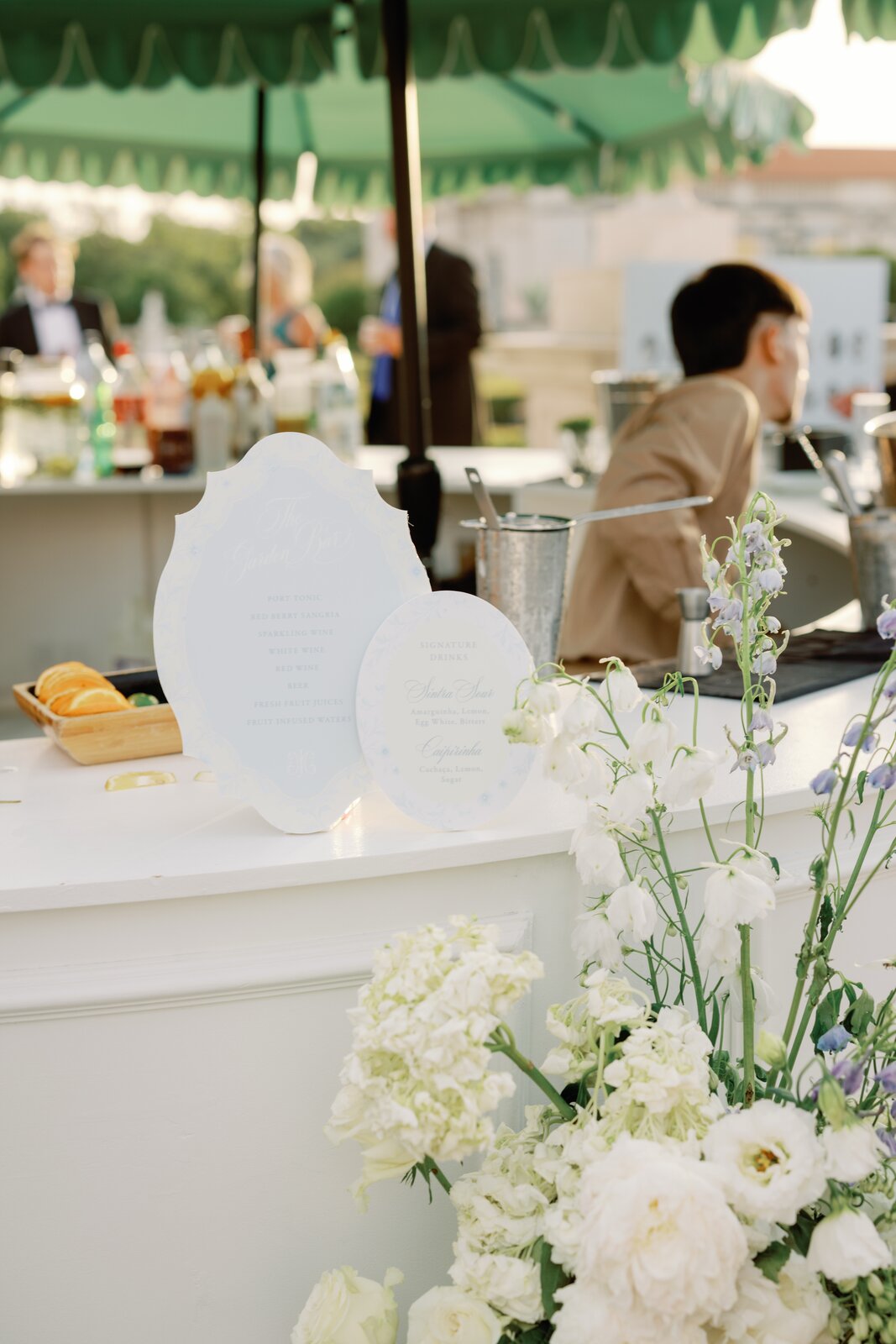 The Garden Bar menu signage with a bartender mixing drinks behind