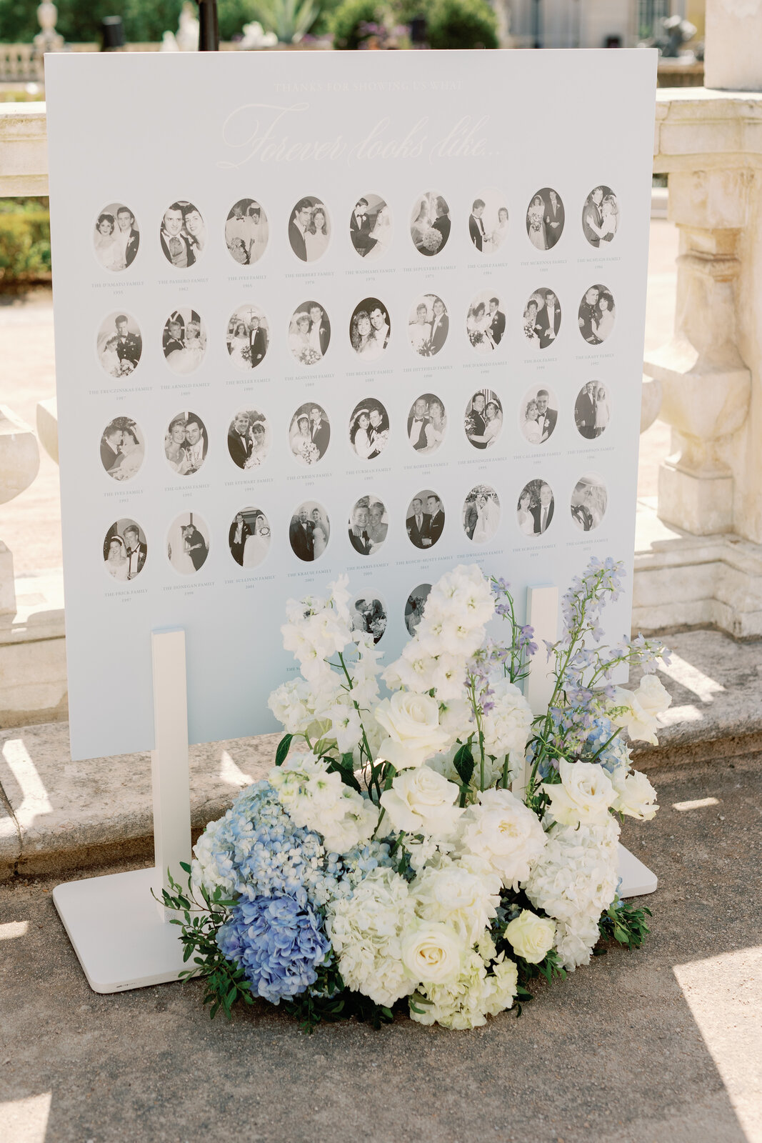 Family wedding photo display board with blue and white floral arrangement
