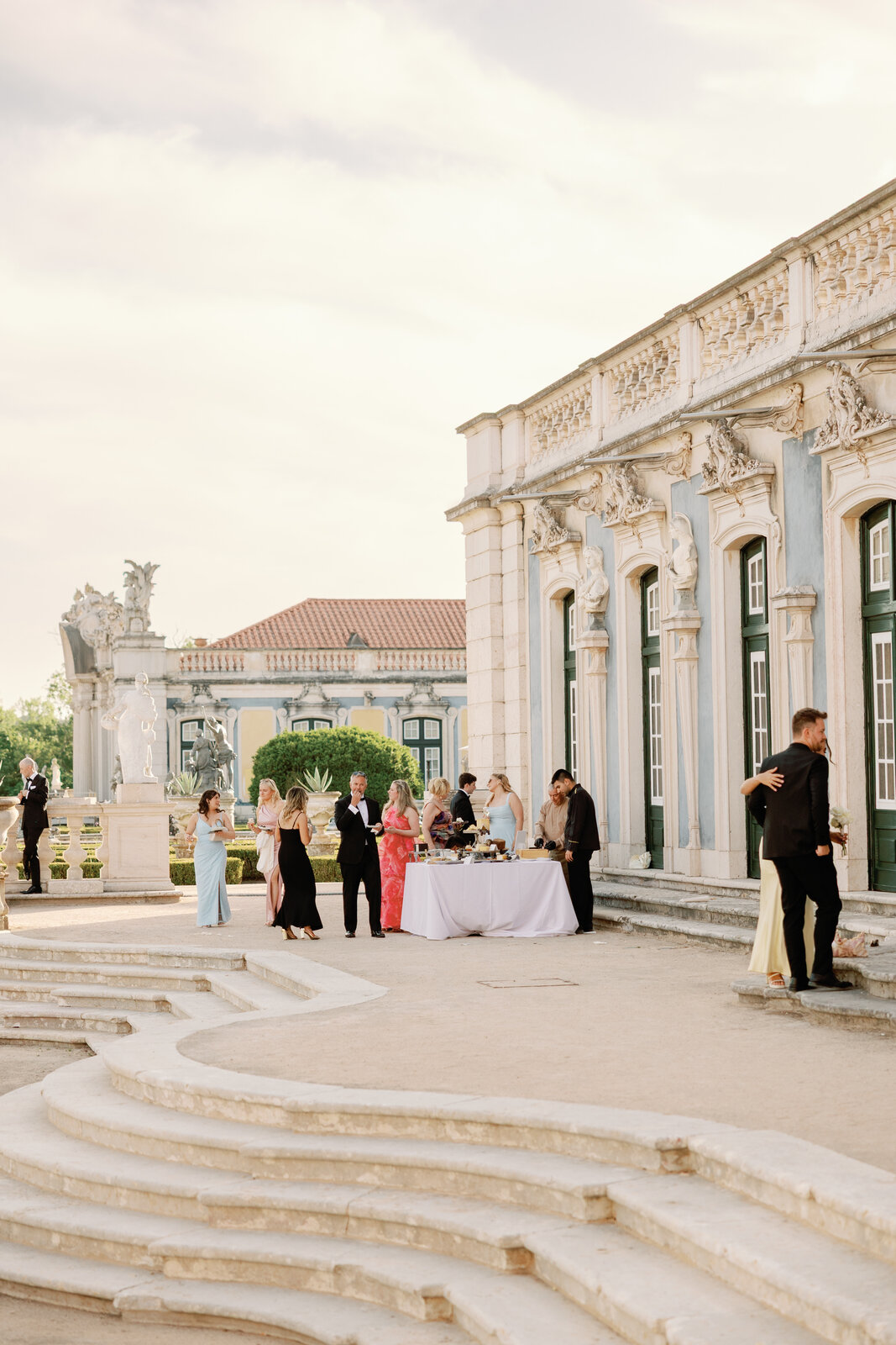 Guests gathered around a buffet table along the palace facade
