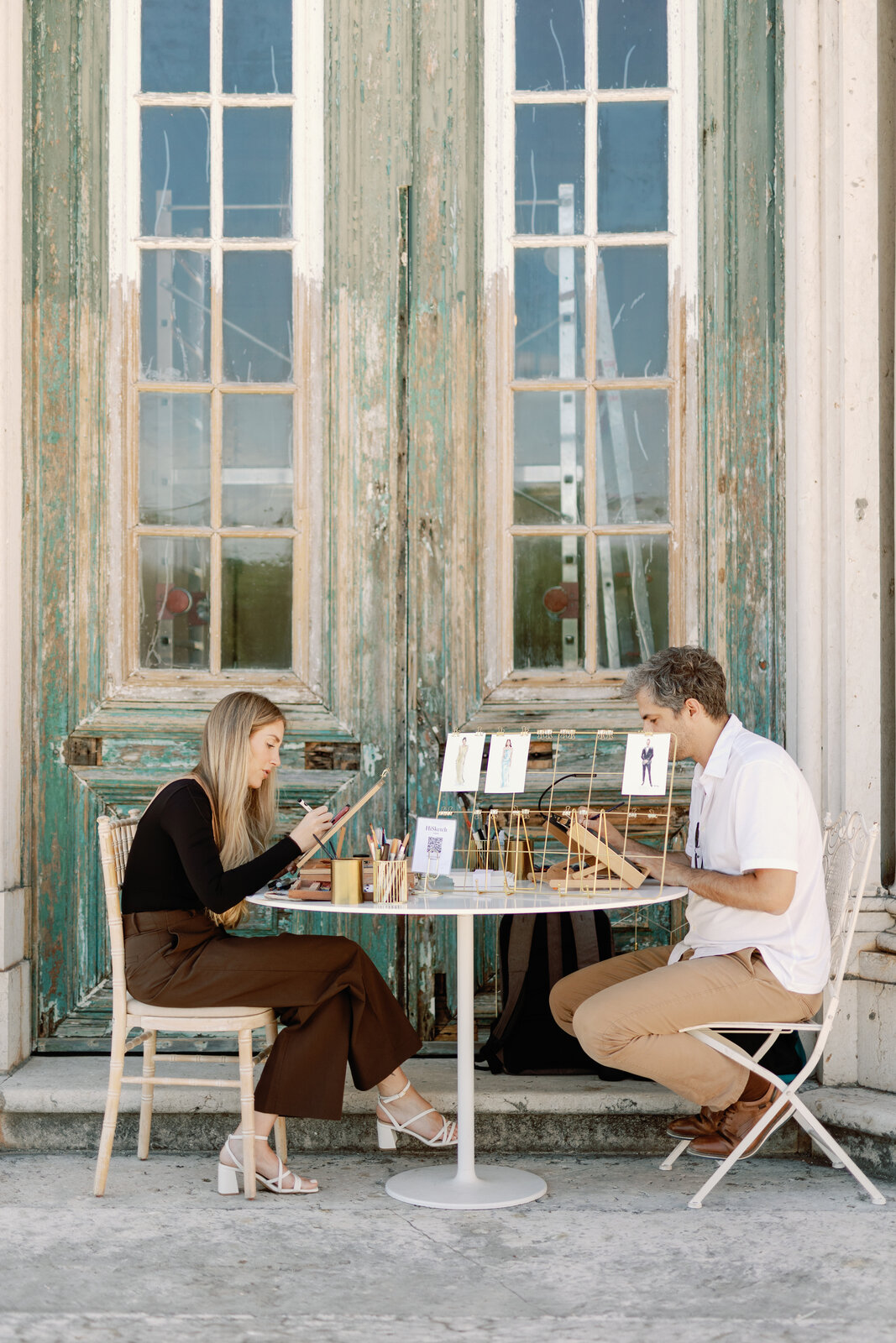 Live sketch artists drawing guest portraits at a café table