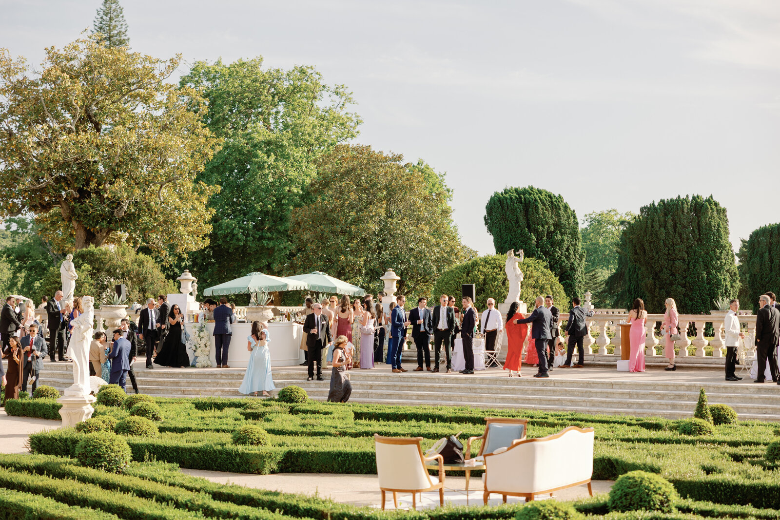 Guests gathered at the terrace bar beneath mint green umbrellas