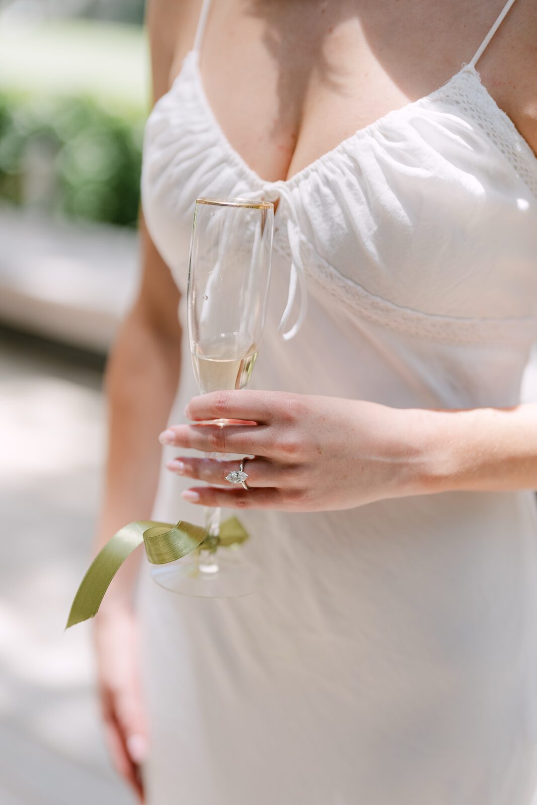 Close-up of the engagement ring with a glass of champagne