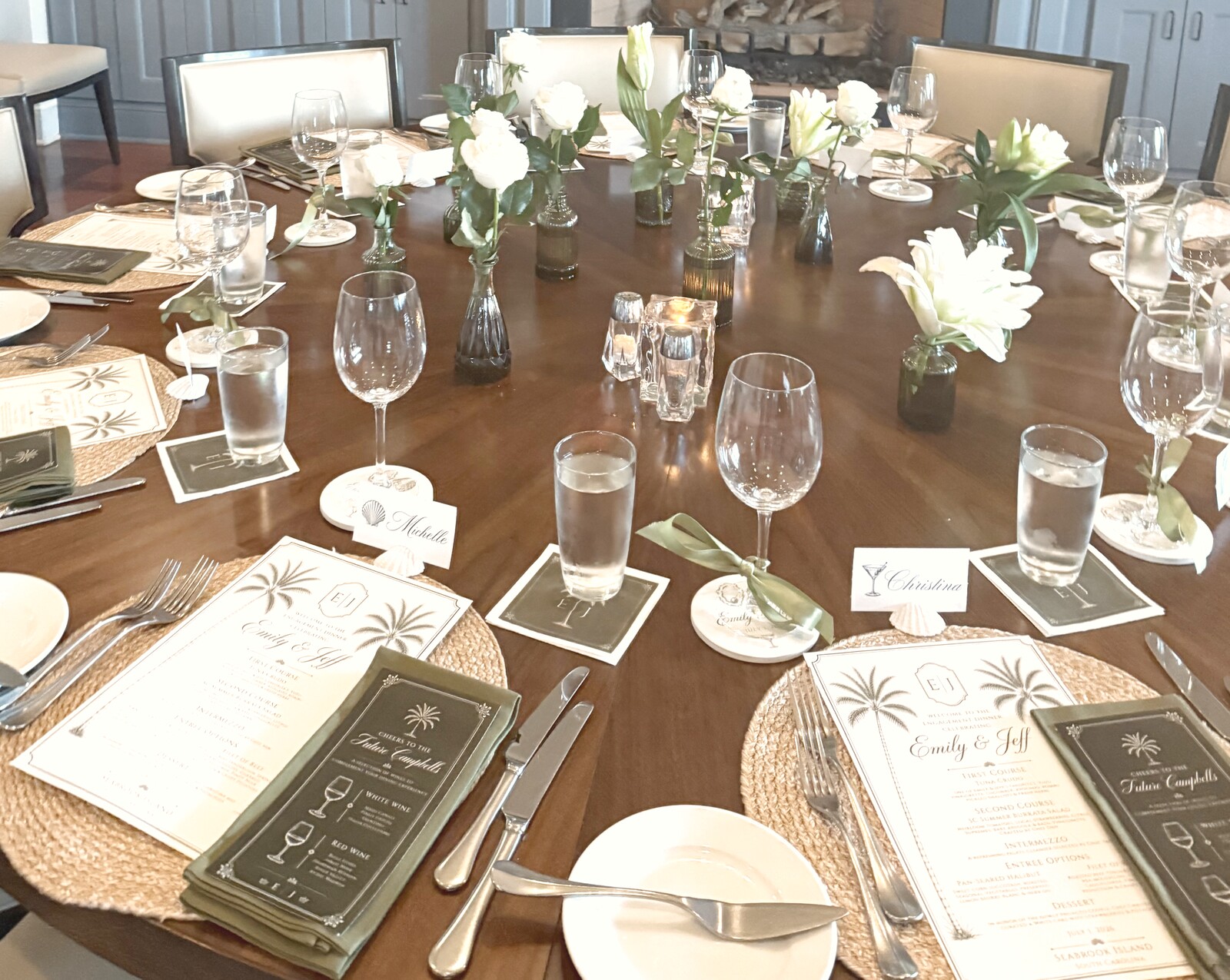 Dinner table set with white roses, palm-print menus, and place cards