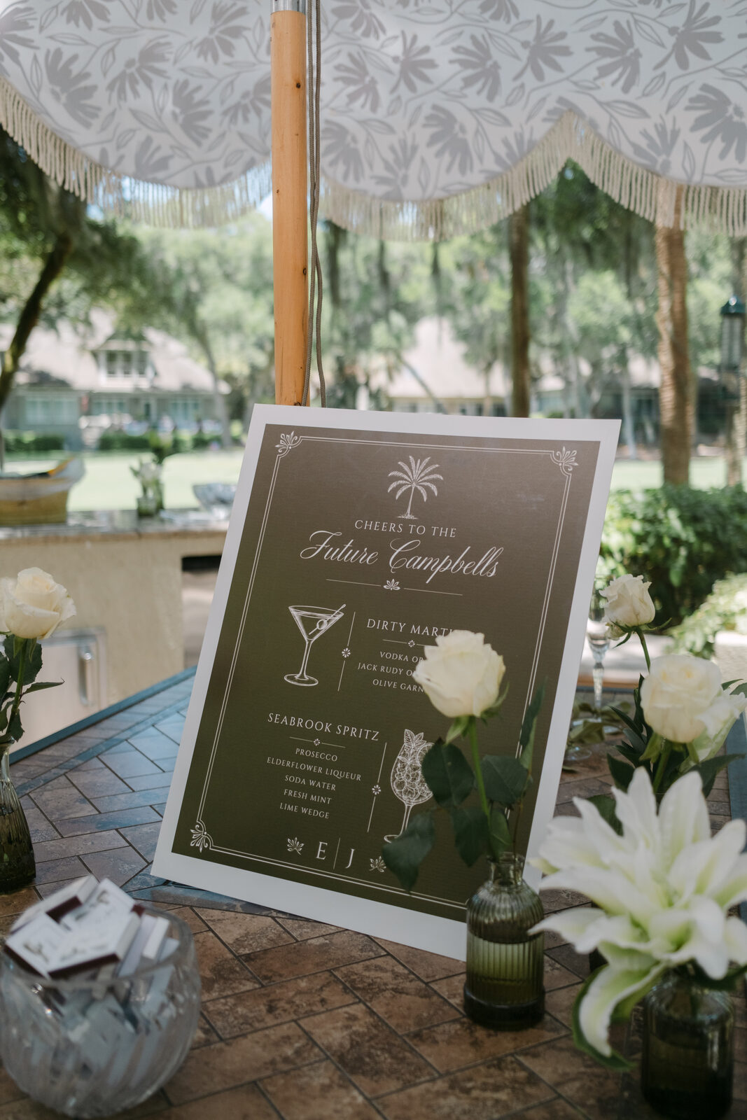 Signature cocktail menu sign displayed among white roses