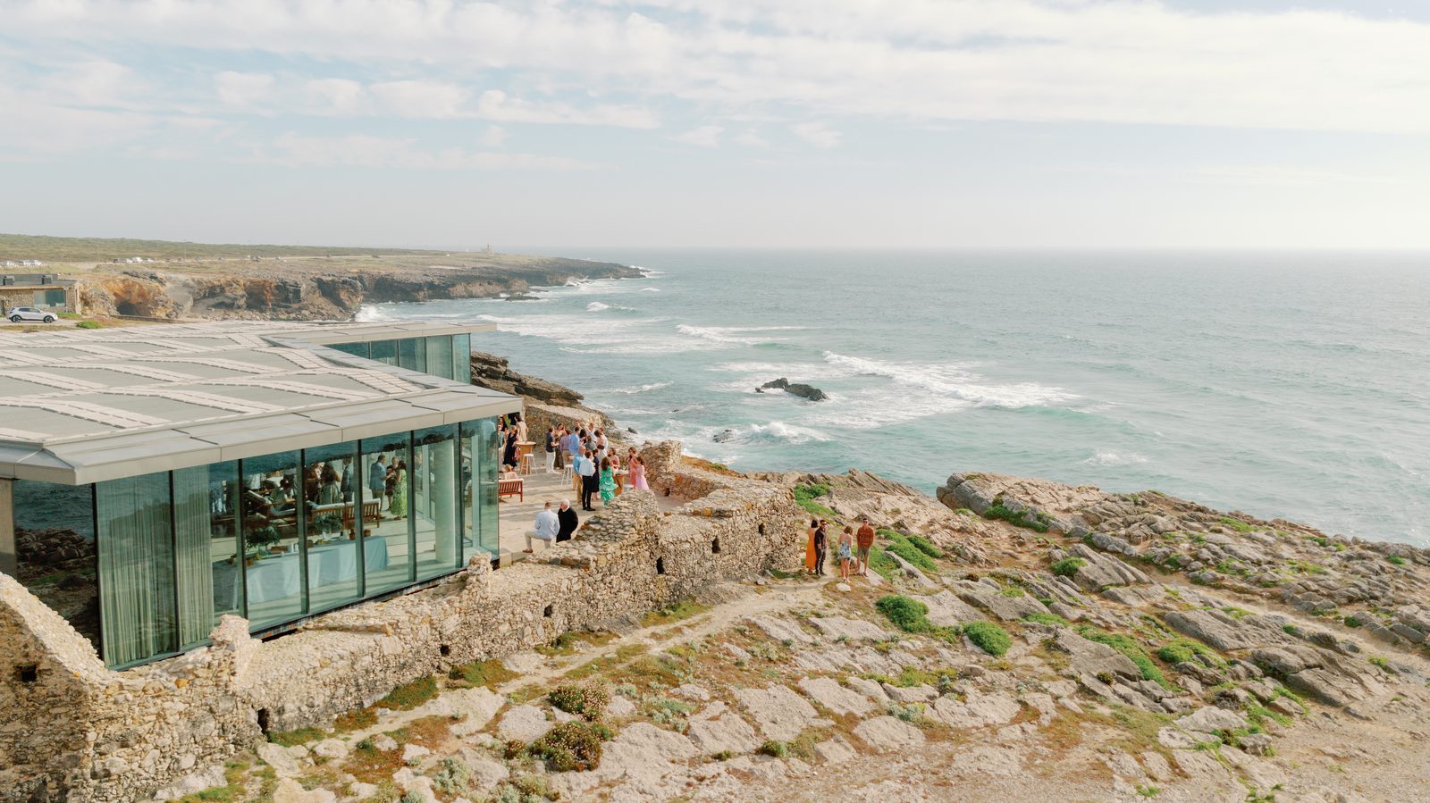 Aerial view of guests gathered for cocktail hour on the cliffside terrace