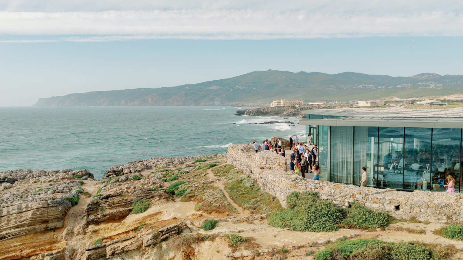 Wide aerial view of the cliffside venue and coastline
