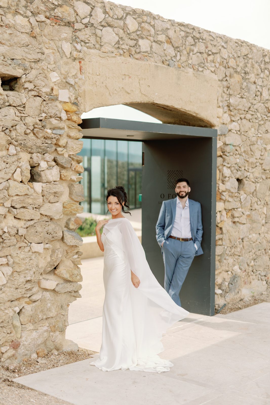 Bride and groom by the stone archway entrance