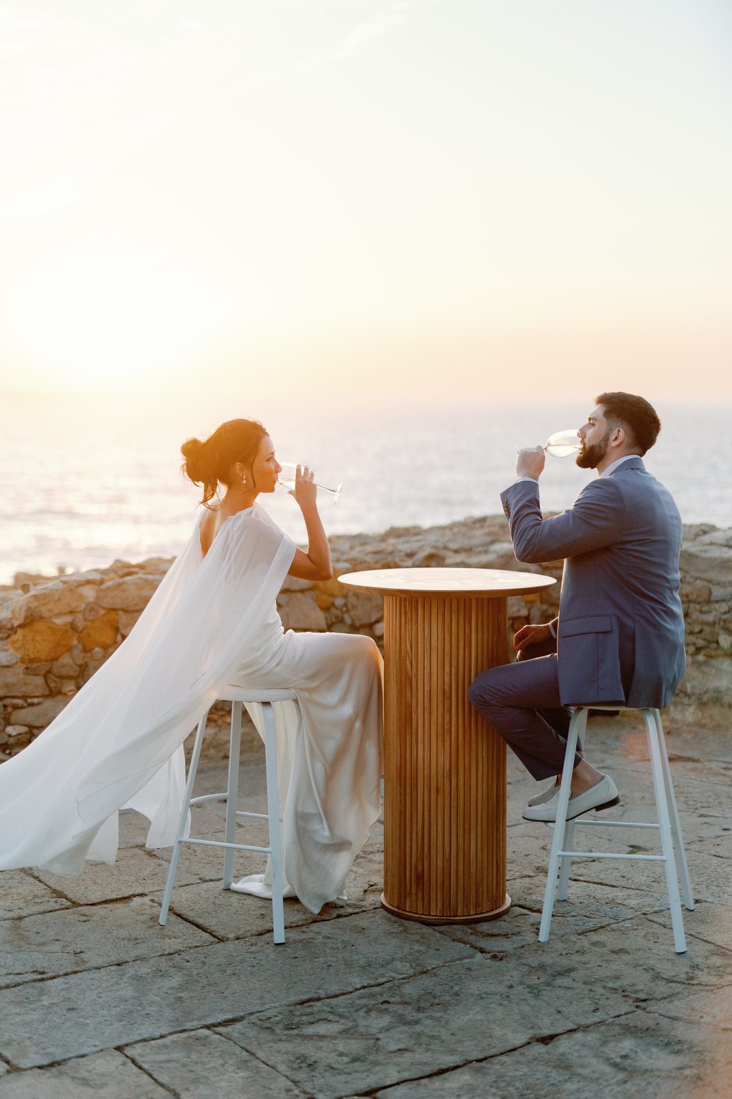Bride and groom toasting champagne at sunset