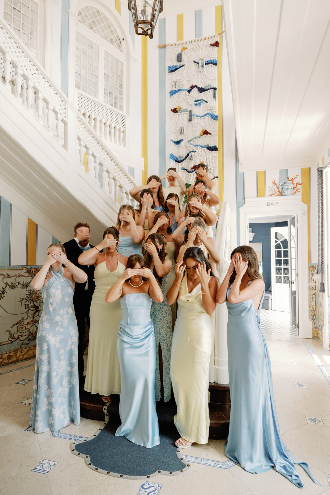 Bridesmaids covering their eyes on the staircase before the reveal