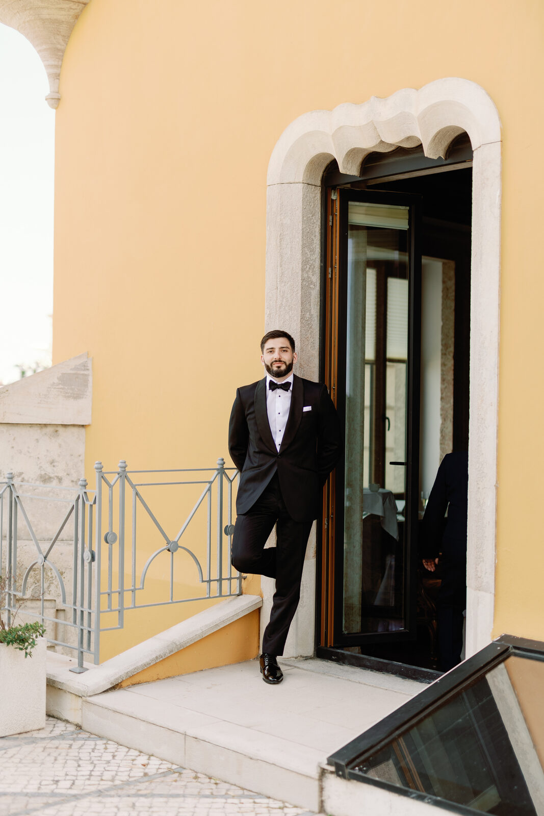 Groom leaning in a doorway of the Albatroz Hotel