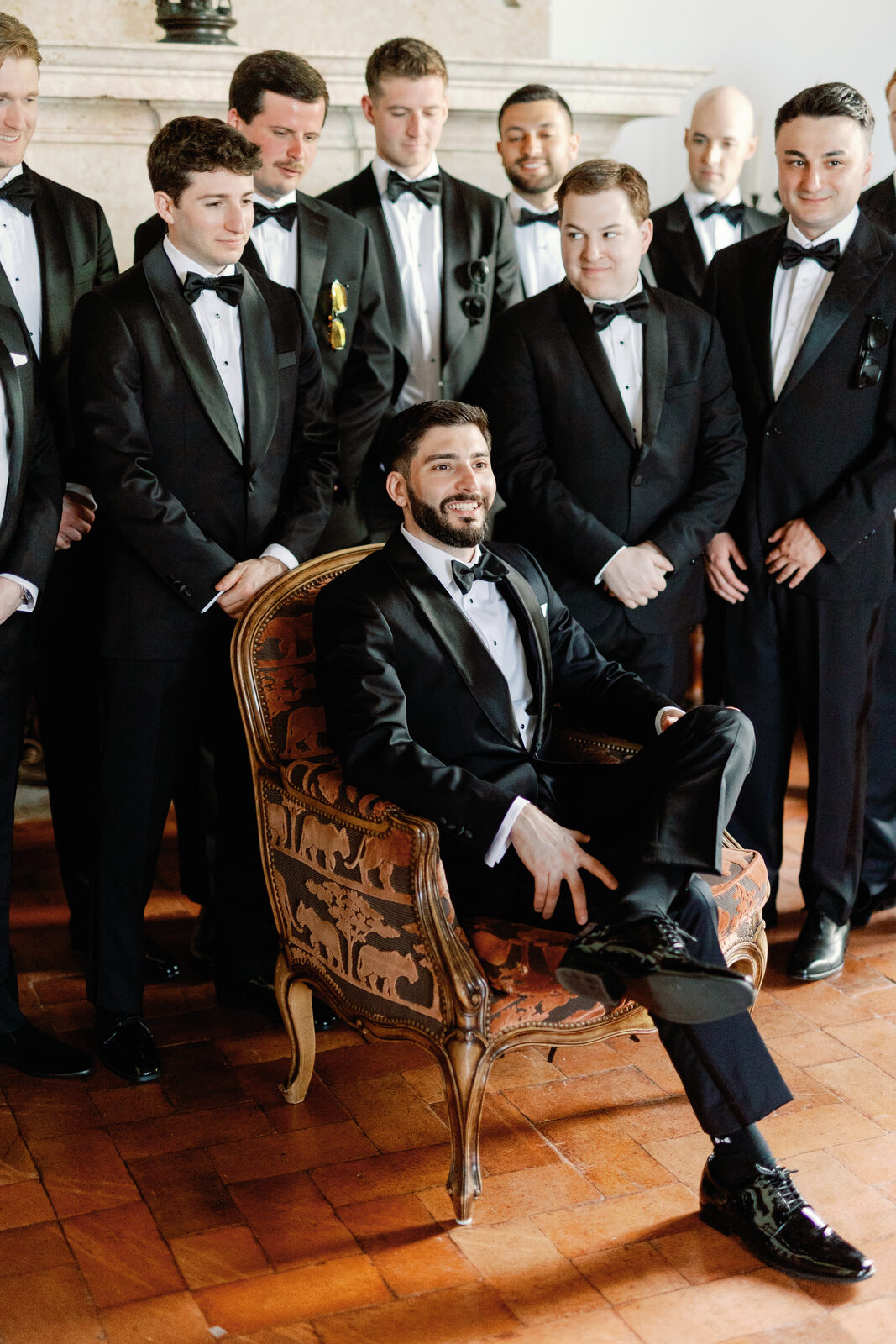 Groomsman seated with feet up, surrounded by the wedding party