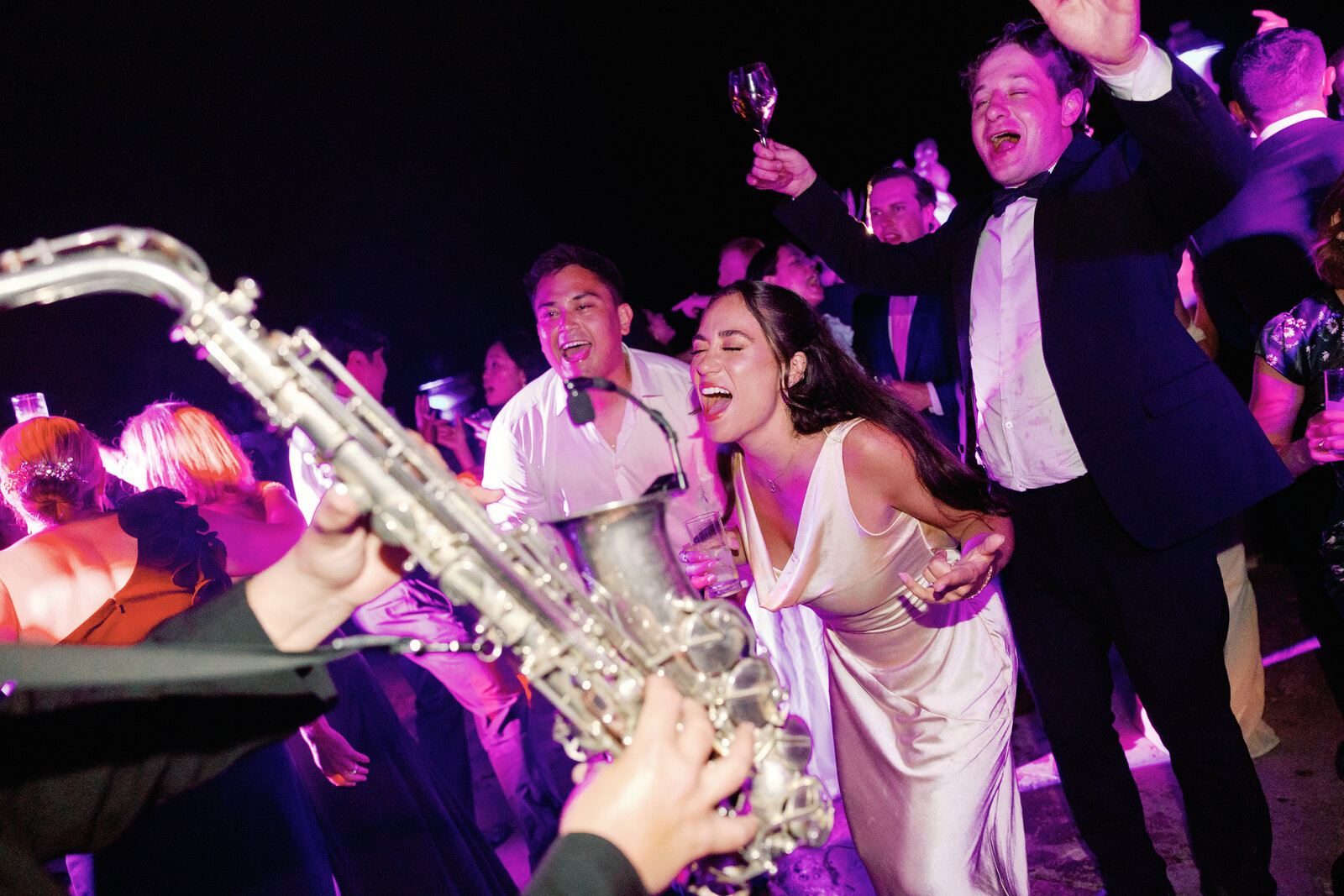 Bride singing into the microphone alongside the saxophonist