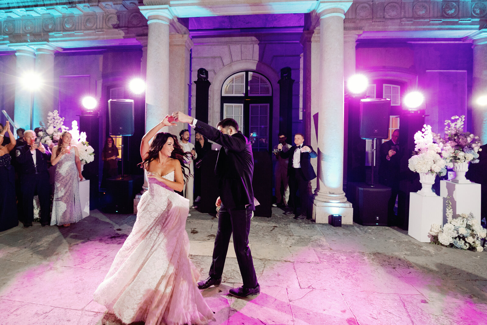 Groom twirling the bride with her hand raised on the dance floor