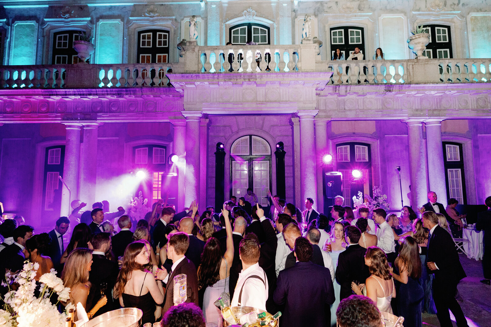 Guests dancing in front of the illuminated palace facade