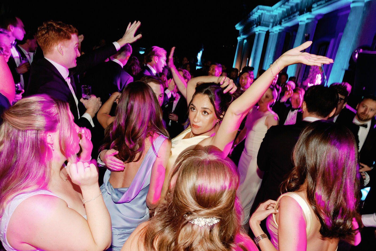 Guests dancing with arms raised on the palace terrace dance floor
