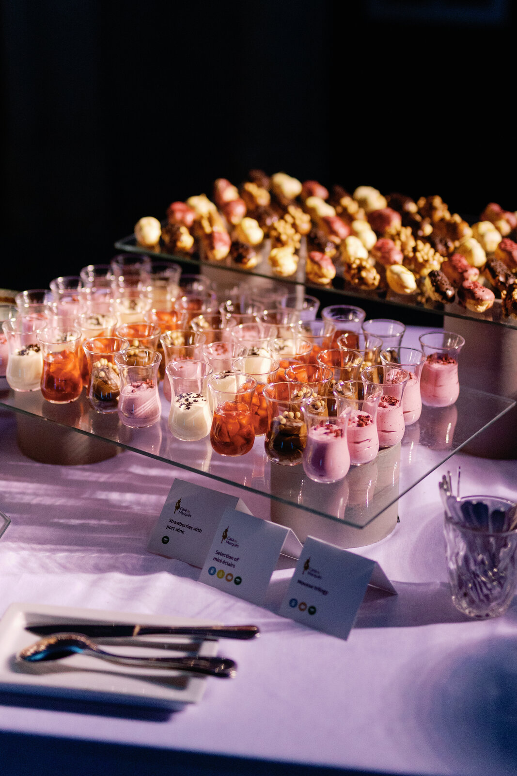 Dessert table with mini éclairs and strawberries with port wine