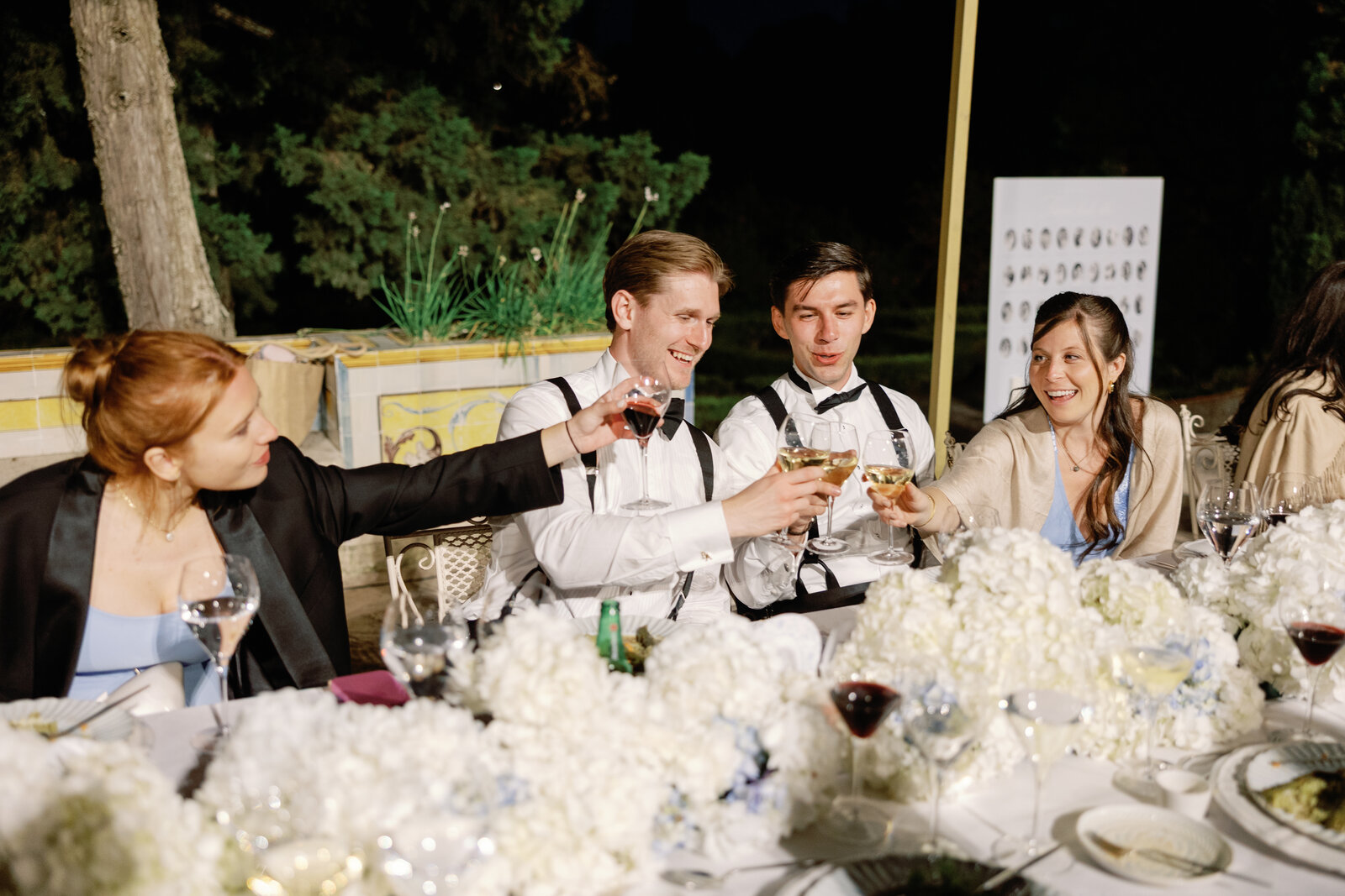 Friends clinking wine glasses together at night