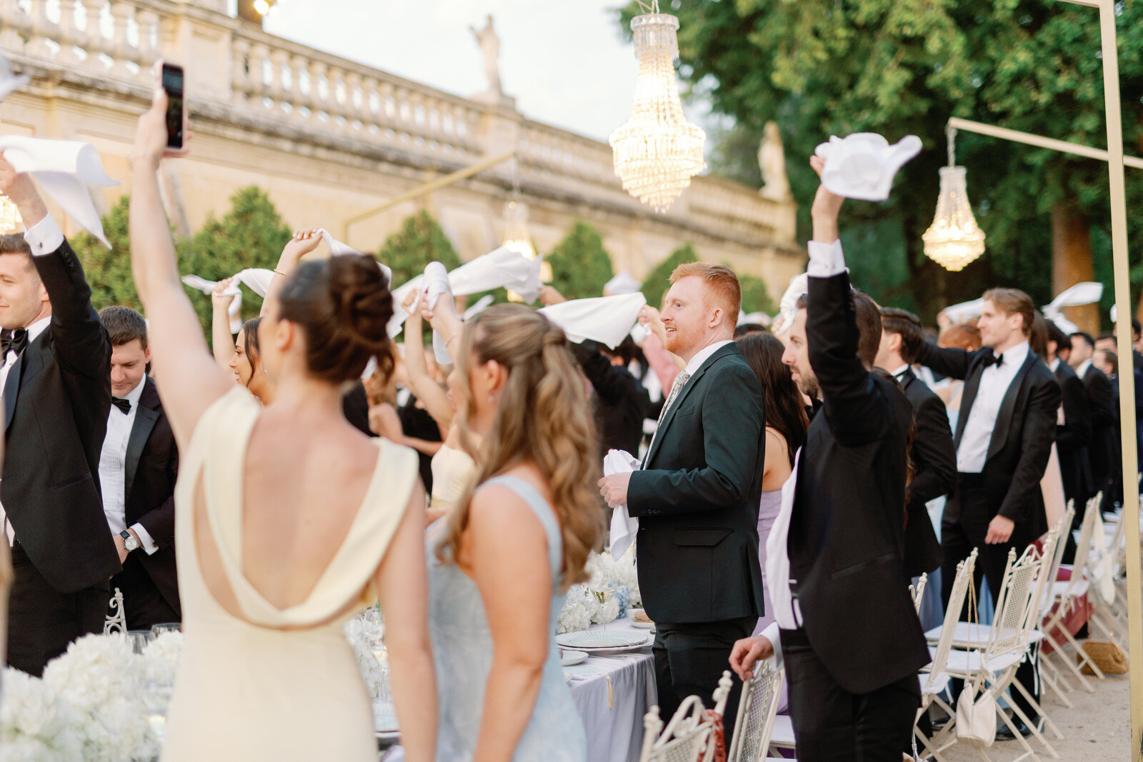 Guests cheering and waving napkins in candid celebration
