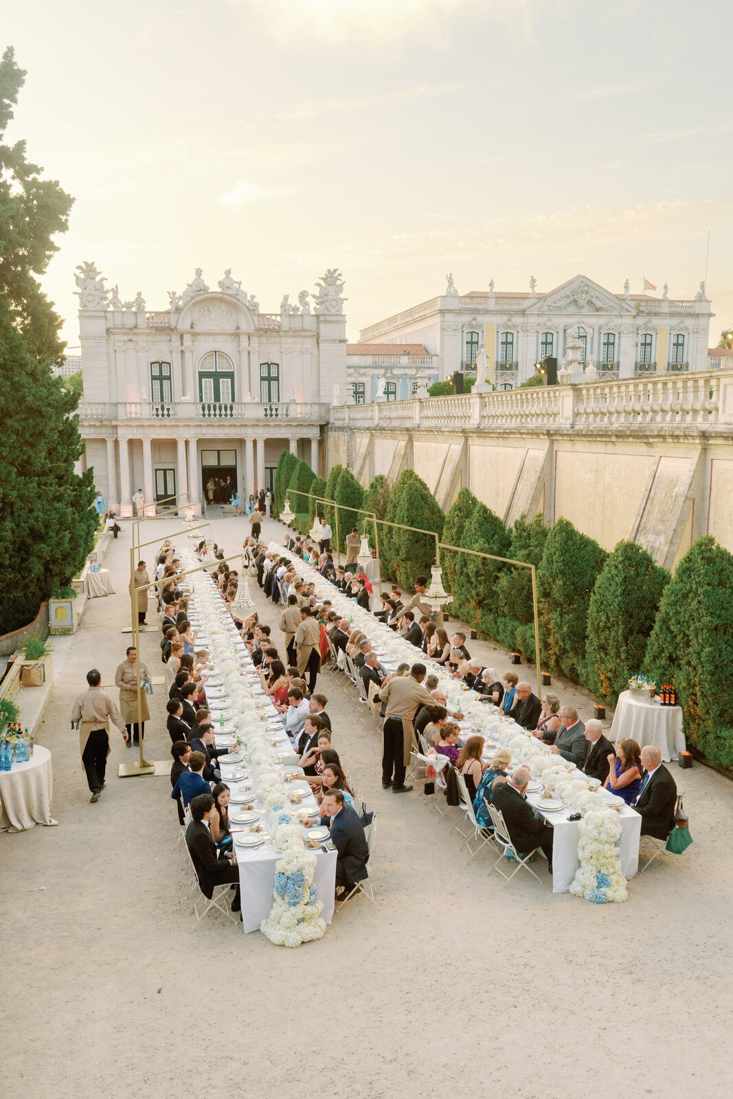 Guests seated and dining at the long tables at dusk
