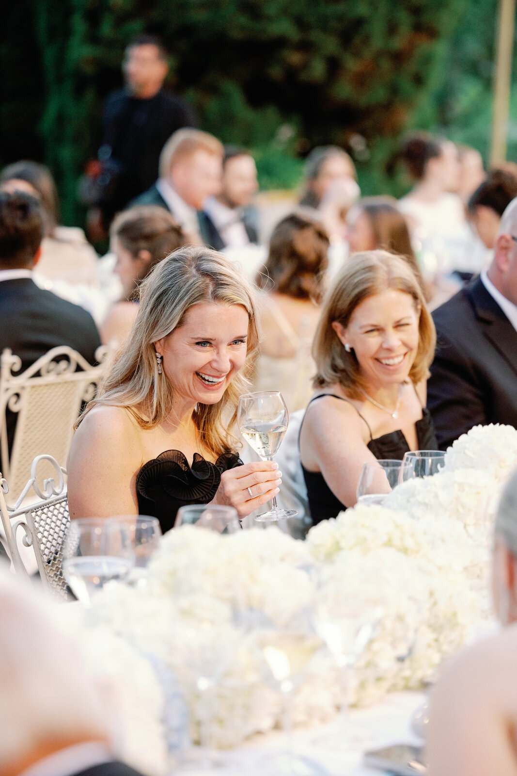 Two guests laughing together with champagne glasses