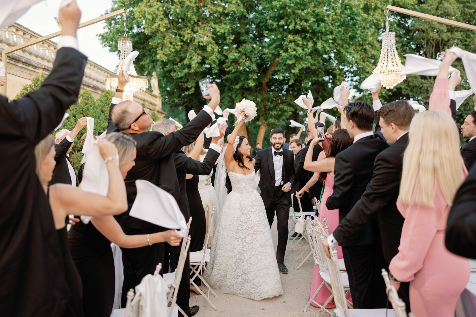 Guests waving white napkins around the bride and groom