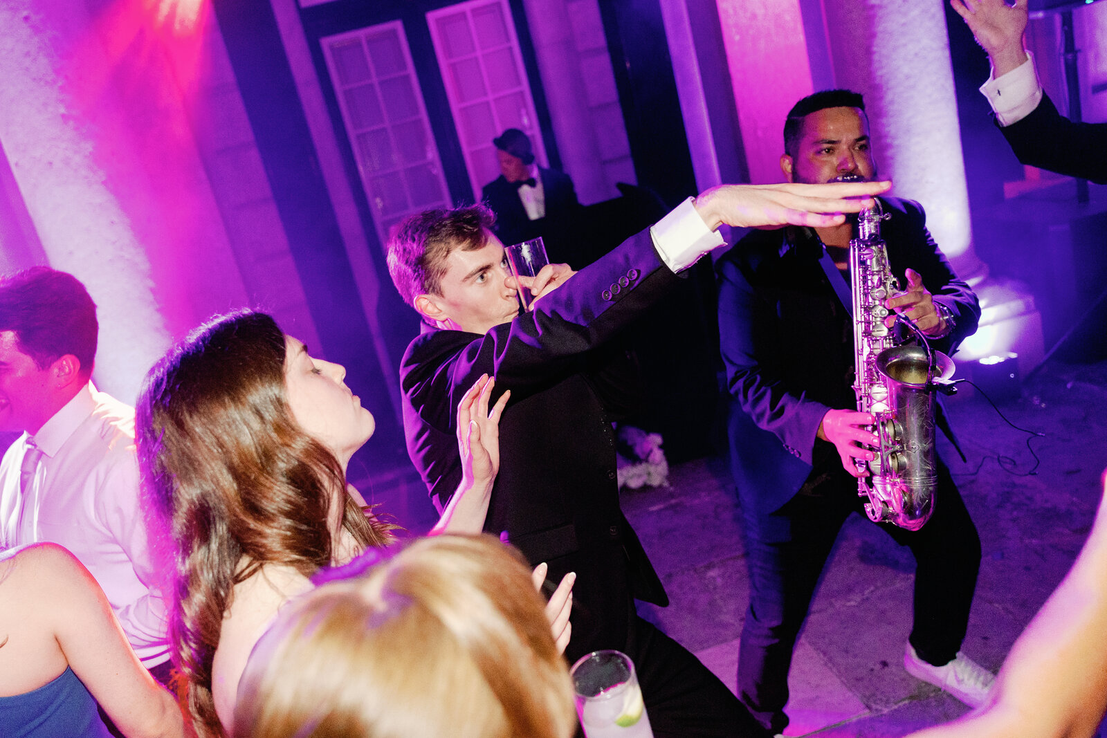 Candid close-up of a guest and saxophonist on the dance floor