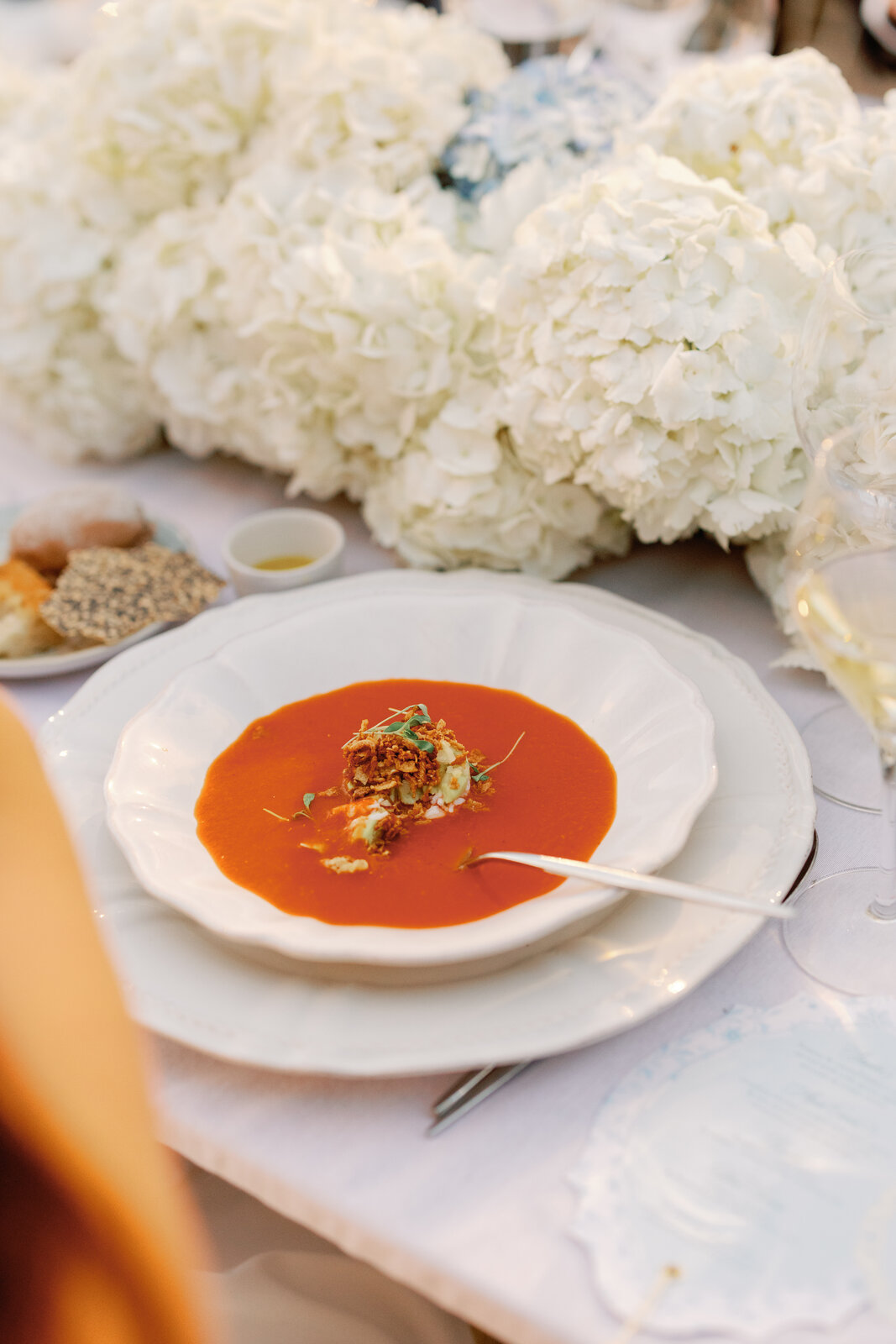 Plated tomato soup course with crispy garnish
