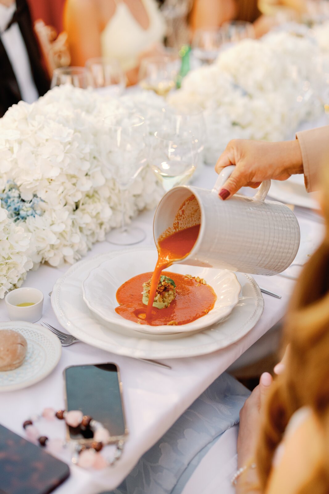 Close-up of the tomato soup course being poured tableside