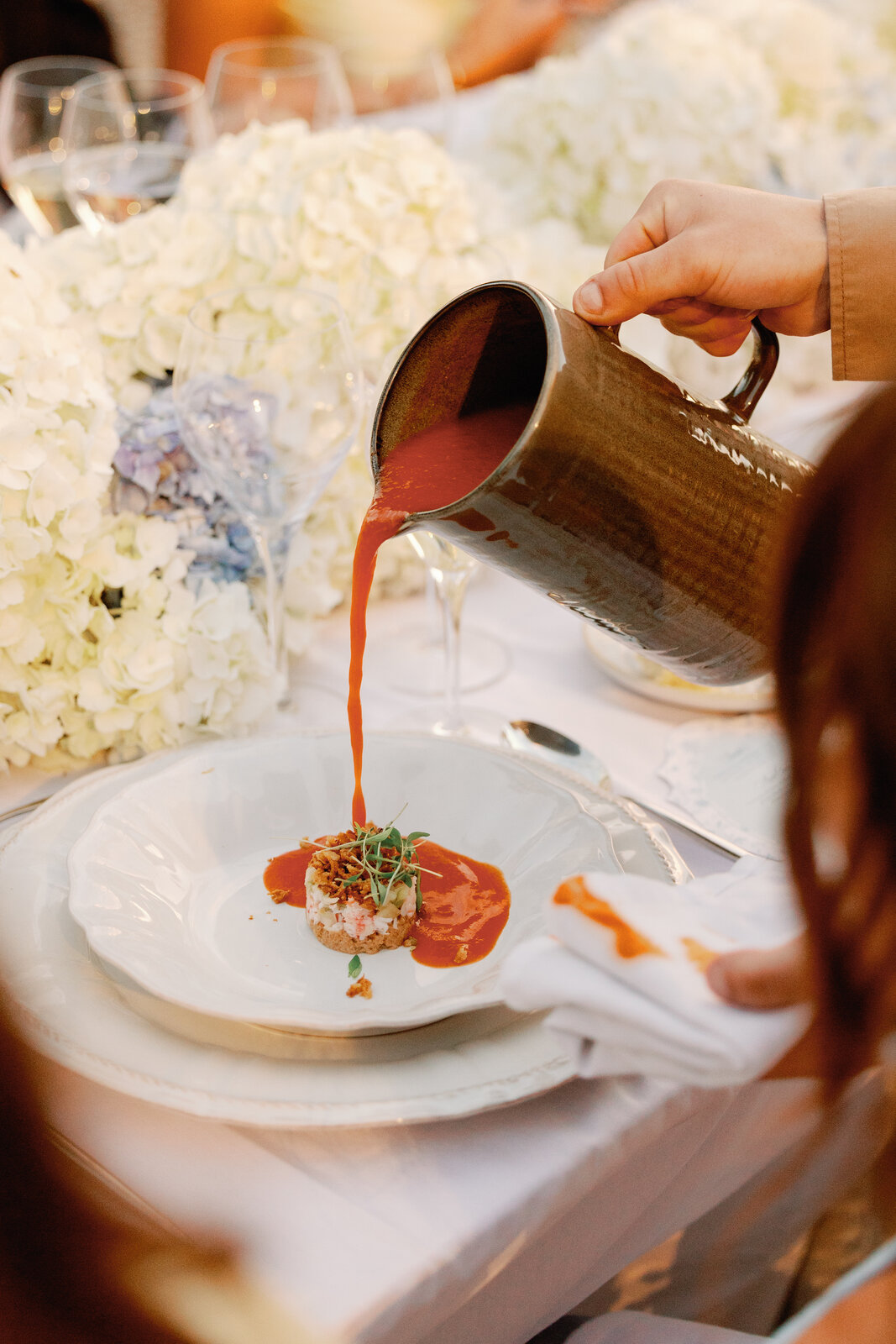 Tomato soup being poured tableside over a crab starter