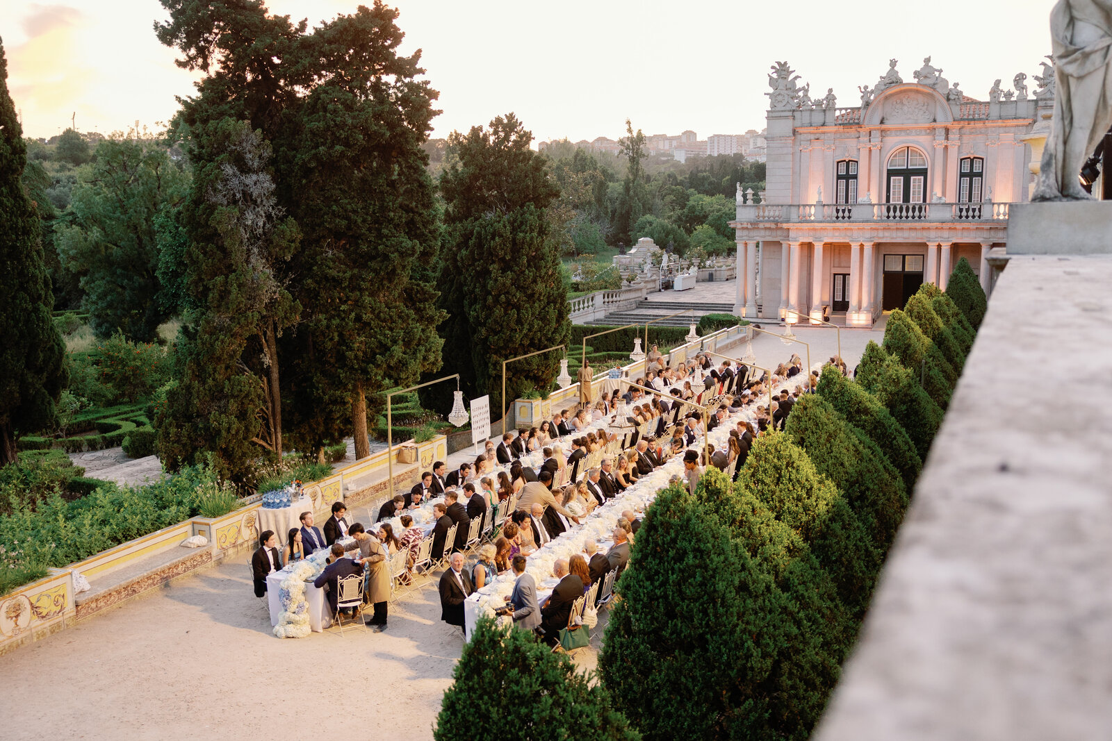 Reception tables at dusk with the palace glowing pink
