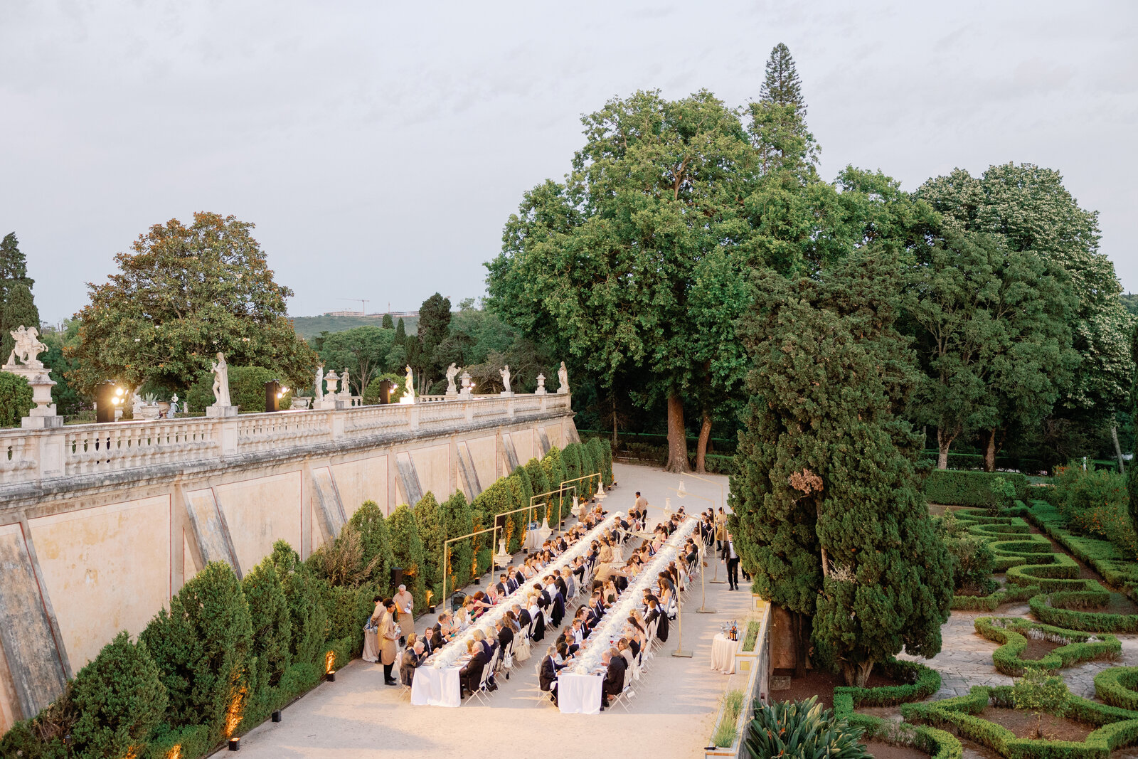 Reception tables along the cypress hedge at sunset