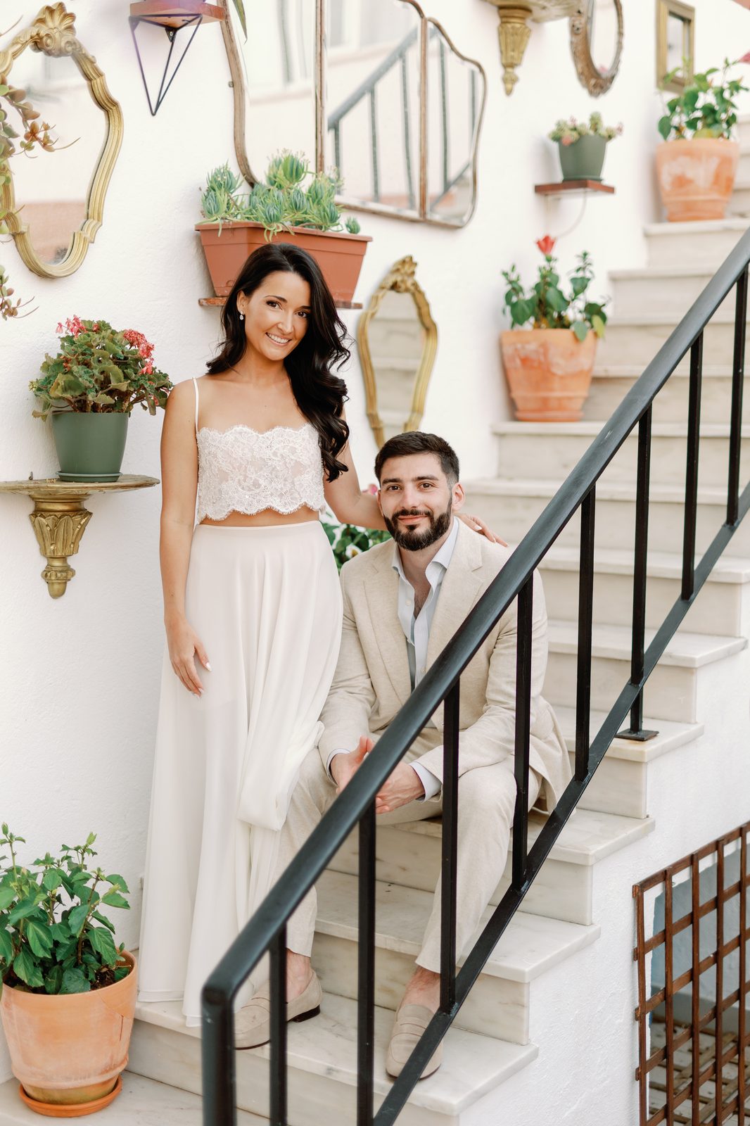 Bride and groom portrait on the staircase surrounded by plants