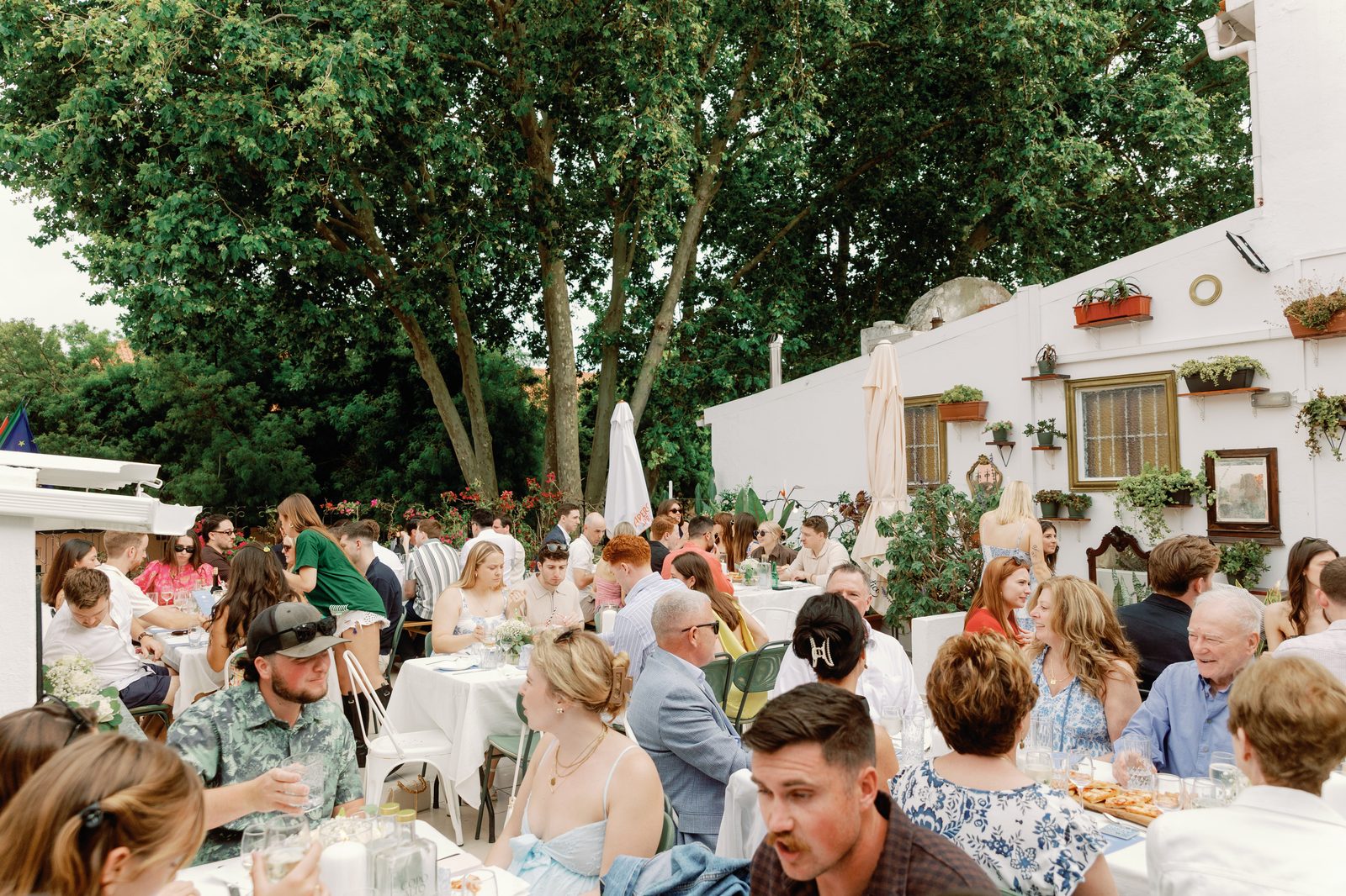 Guests gathered at long tables under the trees