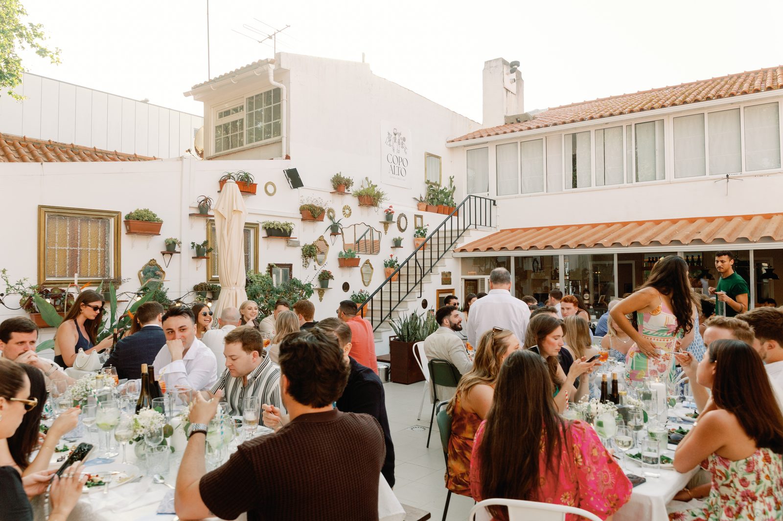 Wide view of the Copo Alto terrace full of dinner guests