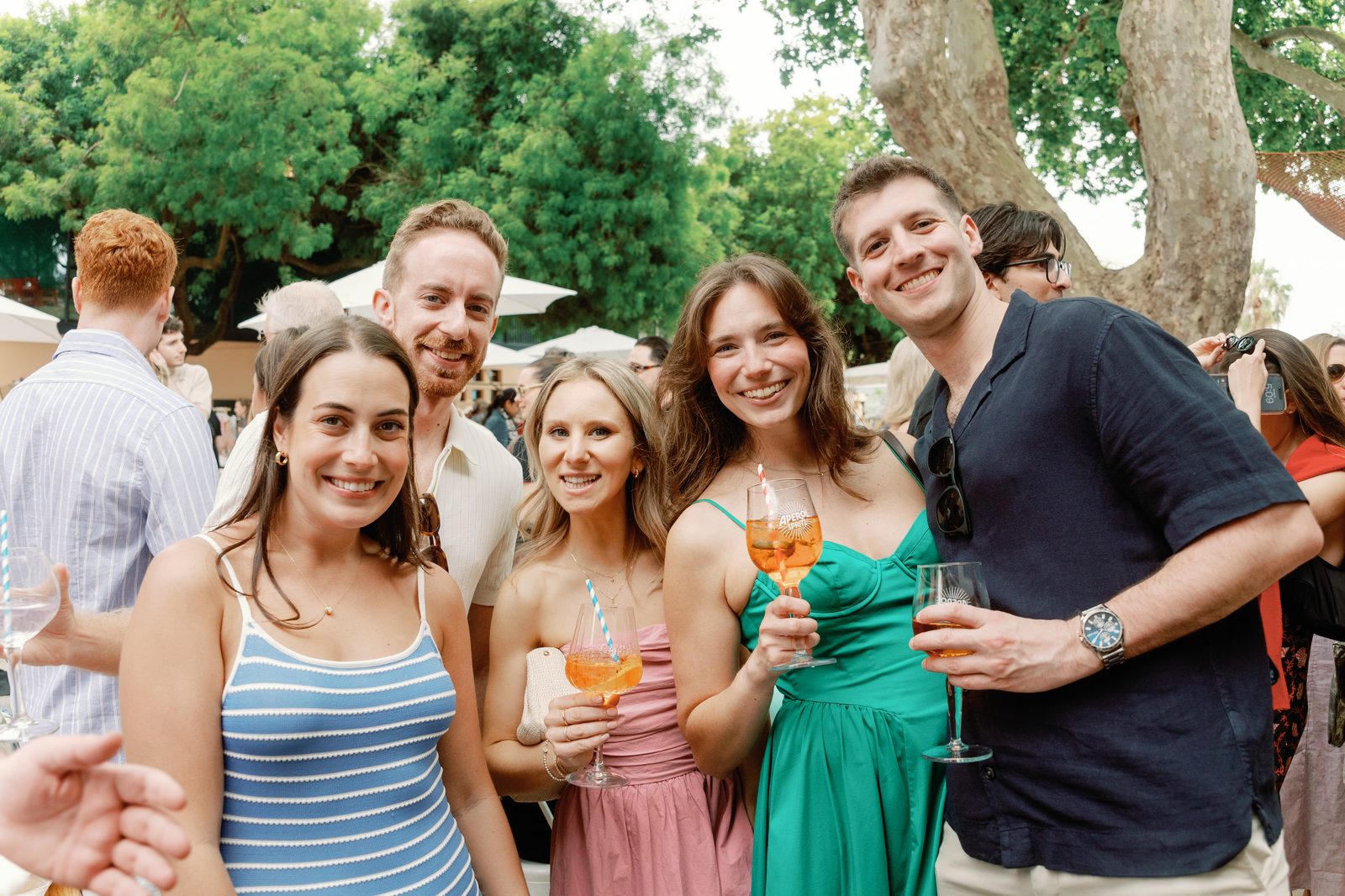 Group of friends holding Aperol spritz cocktails