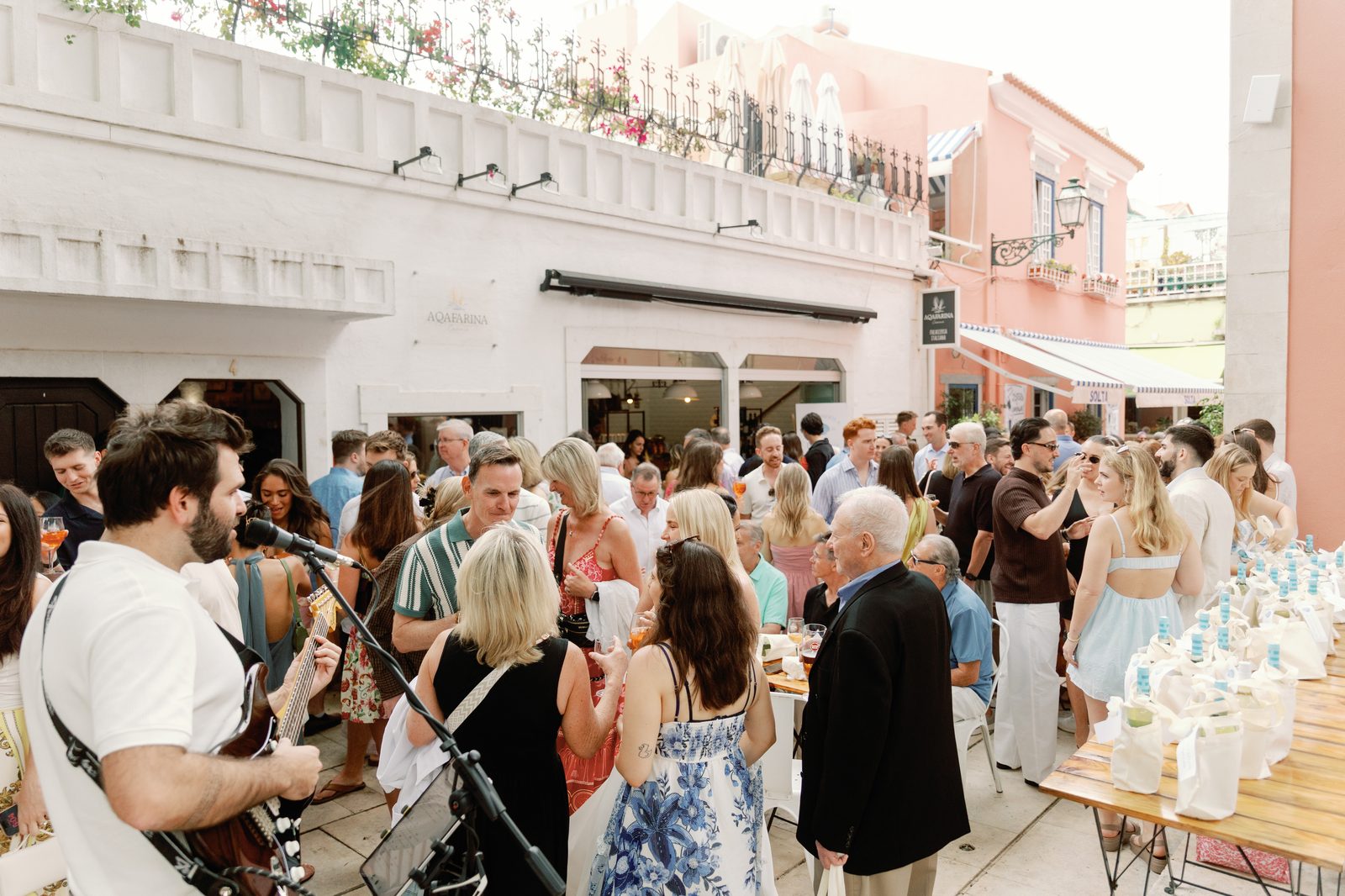 Guests gathered around the live music and welcome bag table