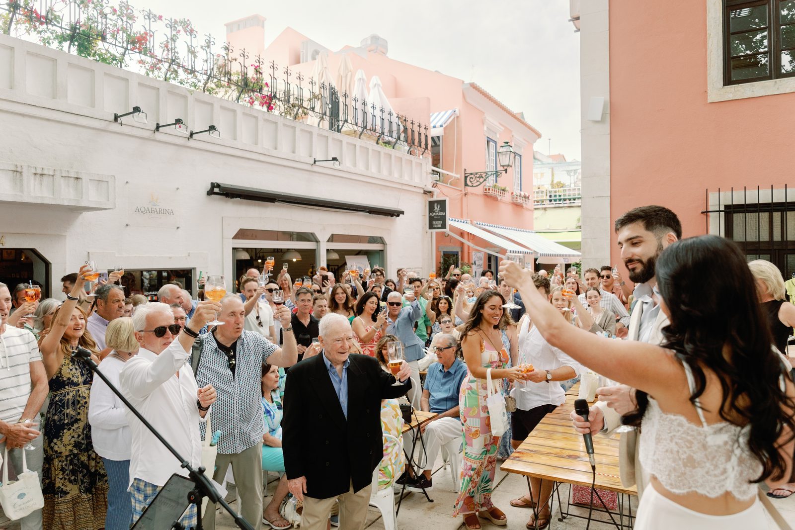 Bride and groom leading a toast with guests raising their glasses