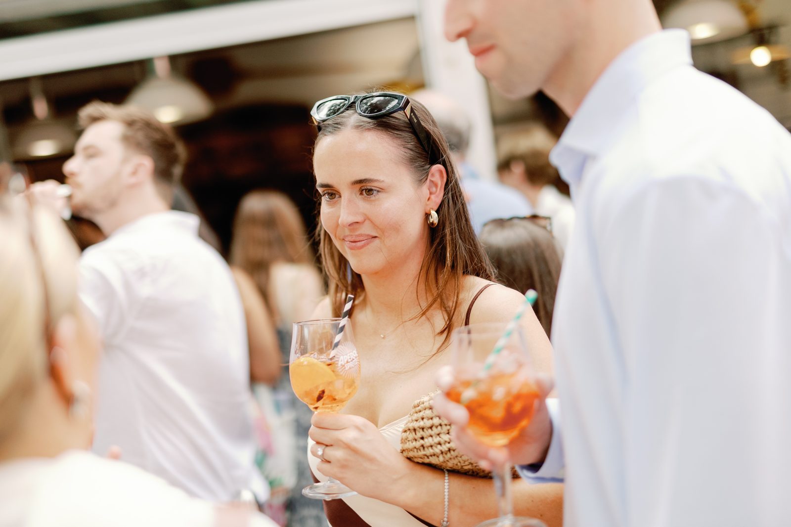 Guest holding two Aperol spritz cocktails